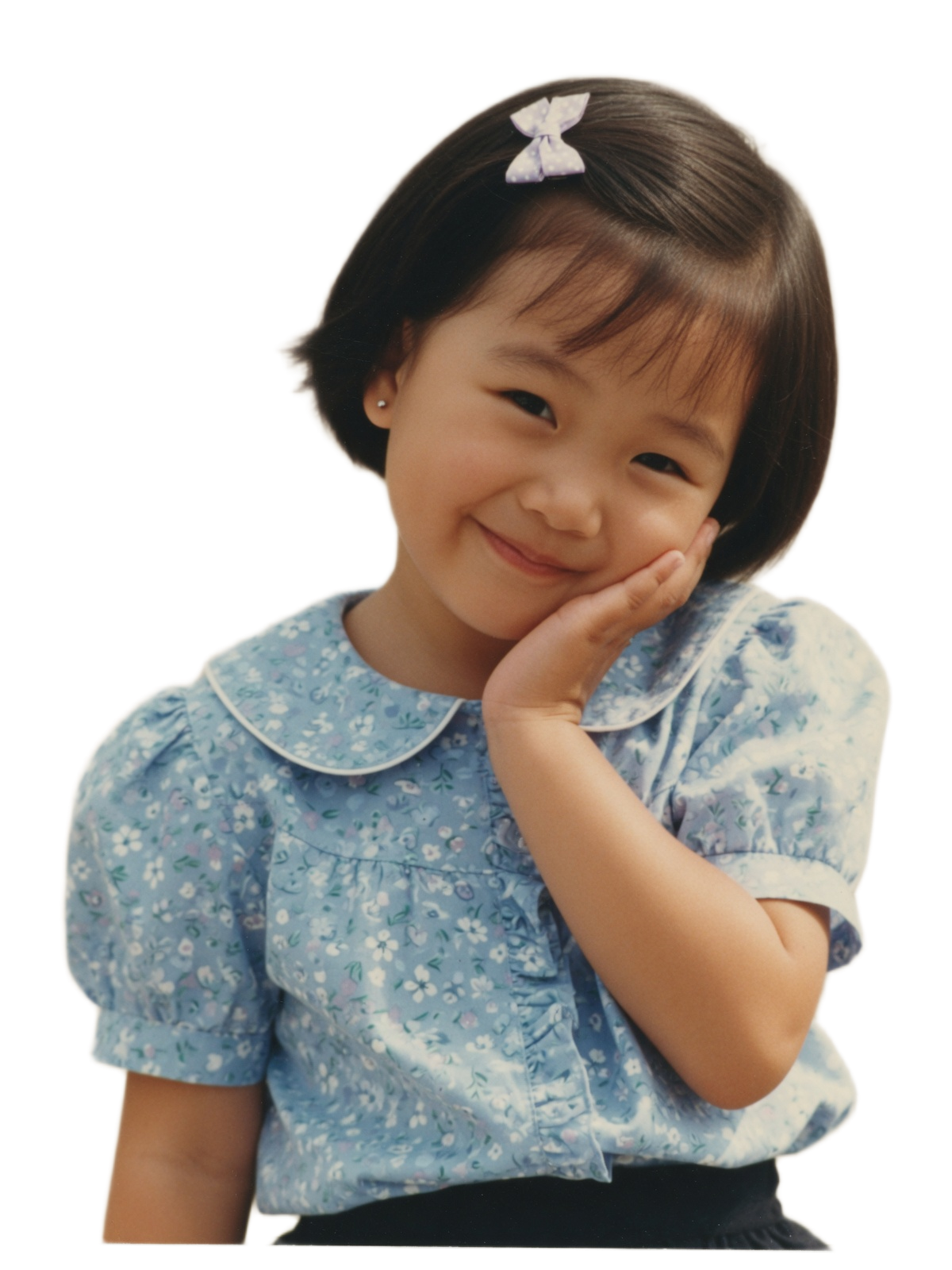 A little girl giving a sweet, shy smile